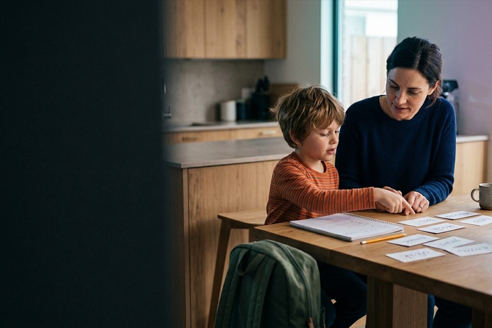 A child turning a spelling worksheet into a learning game at home